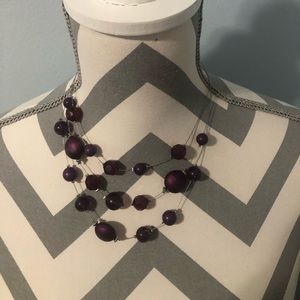Purple beaded necklace that’s adjustable. Measures 18 inches adjustable.